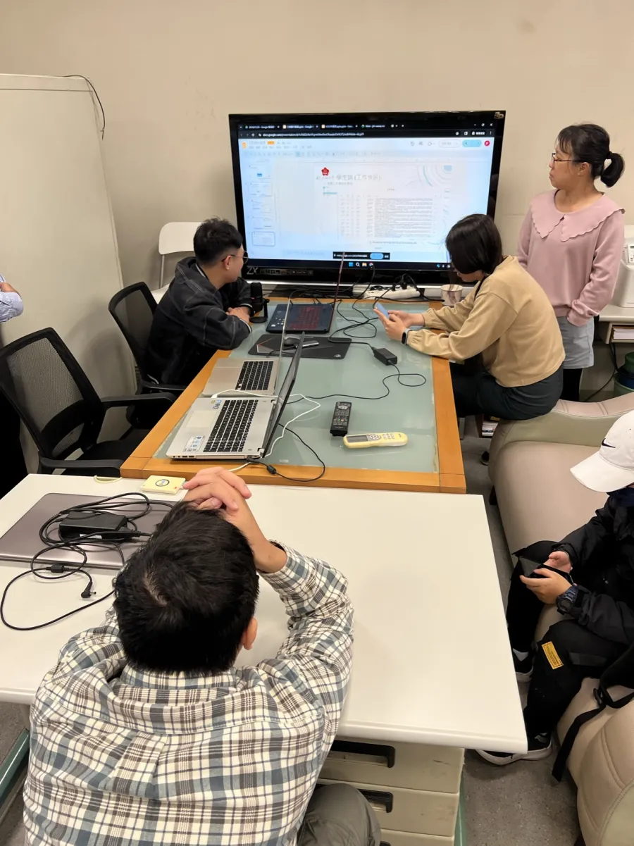 實驗室工作會議 — 成員於大螢幕前討論專案進度